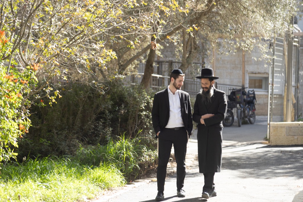 A rebbi walking and talking with a talmid outside