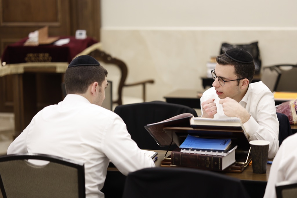 Two talmidim discussing their learning over open sefarim
