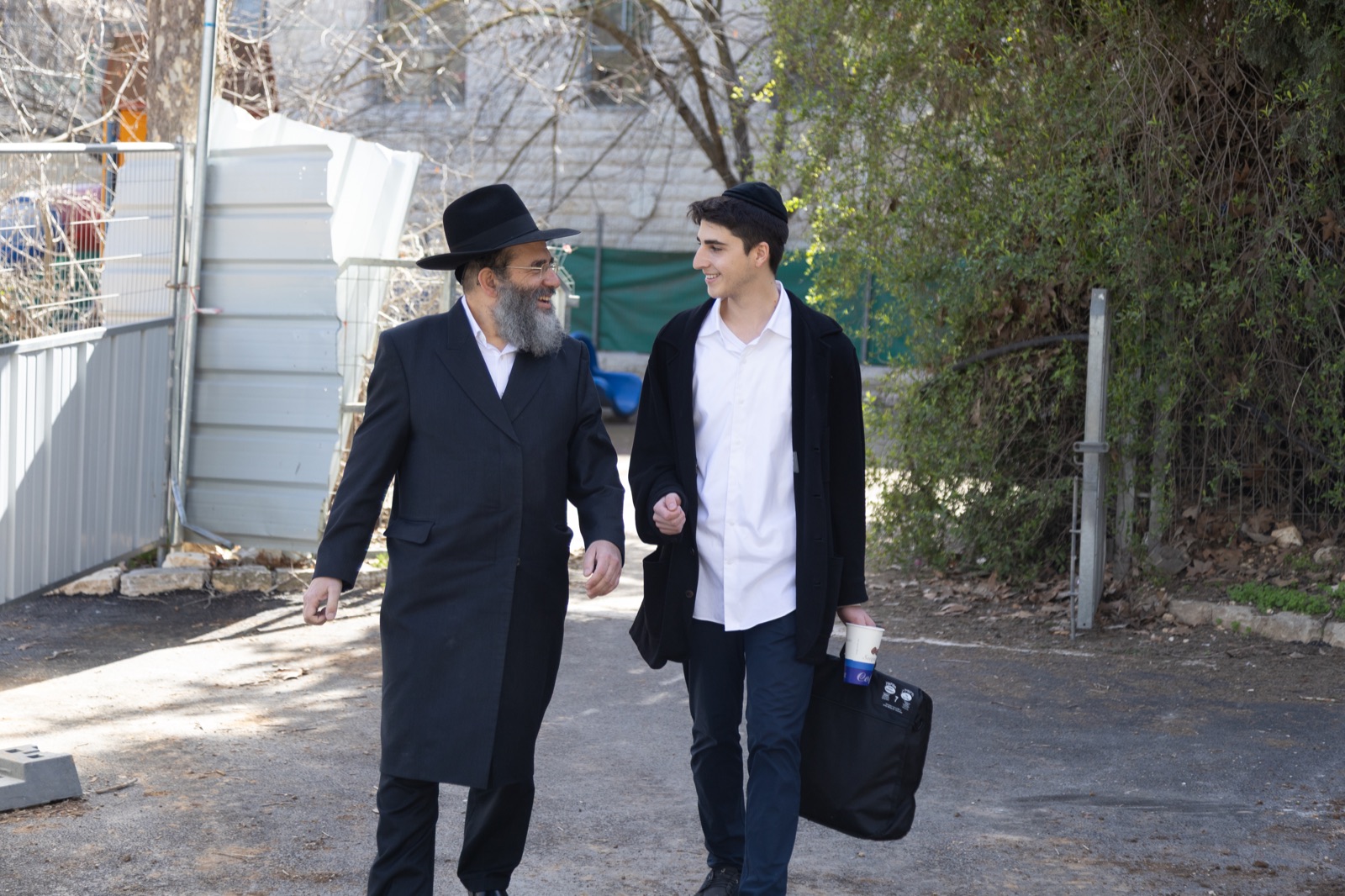 A rebbi walking and talking with a talmid